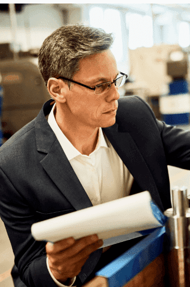quality control inspector examining manufactured steel cylinders in a factory